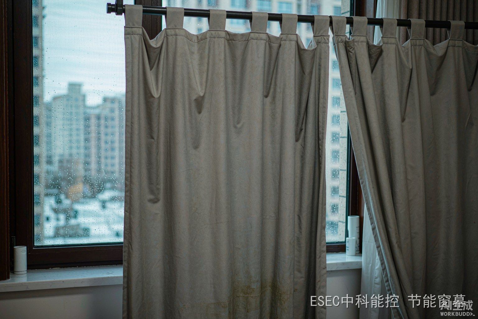 冬季清晨拉开的窗帘下玻璃内侧结满水珠,窗帘下摆有霉斑